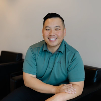 Gene Xiong smiling while sitting.