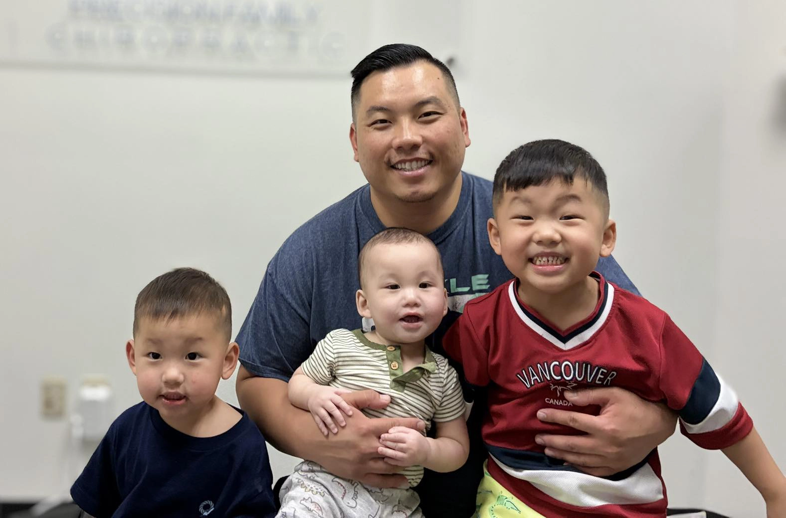 Gene Xiong smiling With his 3 sons.